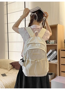 Detail of cream backpack with gold star pattern and cute panda pendant charm