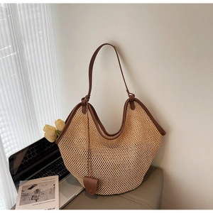 Detailed close-up of woven mesh tote bag with brown leather trim and heart charm