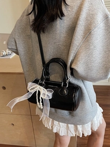 Sac seau cylindrique noir brillant avec pendentif perle et nœud en organza blanc