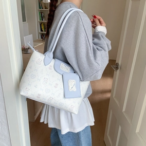 Detail of a large white tote bag with cute animal prints and a mini matching pouch