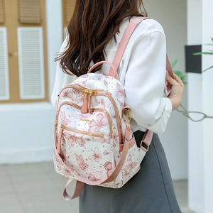 Vue extérieure d'un sac à dos blanc pour femme avec motifs papillons roses et poches de côté