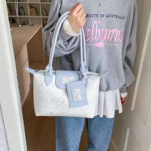 Detail of light blue tote bag set with cute cartoon cat and bear prints and slim straps