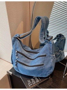 Large blue denim tote bag with multi-zipper pockets and adjustable shoulder strap
