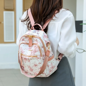 Détail du sac à dos pour femmes avec motifs papillons roses et fermetures éclair dorées