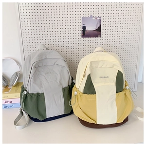 Close-up of color-block nylon backpacks with RGYBAO embroidery and drawstring side pockets
