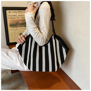 Detail of black and white striped mesh tote bag with durable faux leather shoulder strap