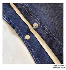 Detail of high-quality silver magnetic buckles on dark blue denim tote bag lining