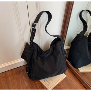Black nylon hobo bag showing large storage capacity and adjustable silver buckle strap