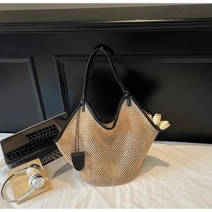 Détail du sac cabas en paille tissé main avec bordures en cuir noir et design hobo