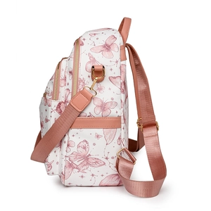Détails du motif papillon rose et des fermetures éclair dorées du sac à dos