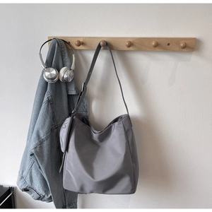 Detailed view of gray nylon tote bag with detachable mini pouch and long shoulder straps