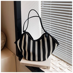 Close-up of black and white striped mesh woven tote bag with premium leather handle