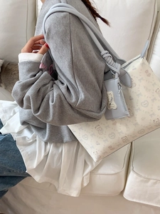 Large blue tote bag with cute bear prints and matching coin purse on a sofa