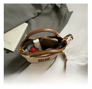 Detail view of the interior capacity and embroidered MR logo on the woven crossbody bag