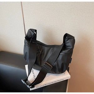 Detail of black nylon crescent bag featuring wide adjustable strap and zipper pocket