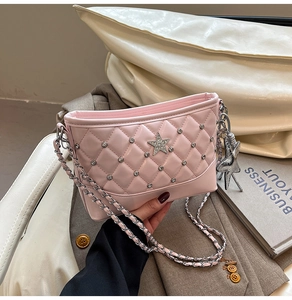 Detailed close-up of pink quilted crossbody bag with star-shaped charms and silver chain