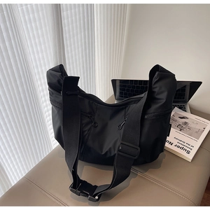 Detail of black nylon crossbody bag with multi-zipper pockets and wide strap