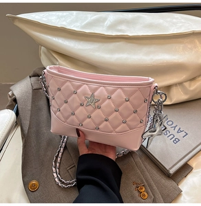 Detail of pink quilted leather bag featuring a crystal star and silver star pendant
