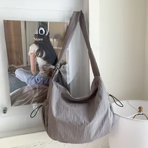 Detail view of grey hobo bag showing textured fabric and drawstring side accents
