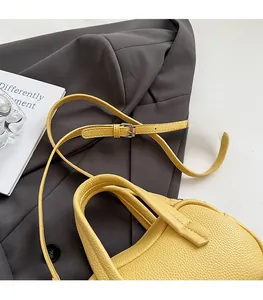 Détail d'un sac à main en cuir grainé jaune avec bandoulière et boucle argentée