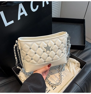 Close-up of beige quilted chain bag with rhinestone star detail and luxury textures