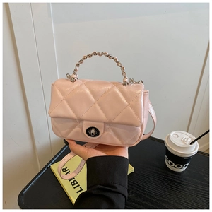 Detail of light pink quilted crossbody bag with metal chain handle and turn-lock closure