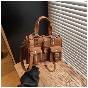 Detail of vintage brown faux leather handbag with silver buckles and multi-pocket design