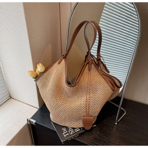 Détail du sac cabas en paille tressée avec anses en cuir marron et décor de tulipes