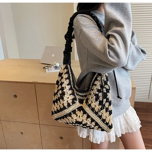 Detail of hand-woven tote bag featuring black and yellow checkers with ruched strap