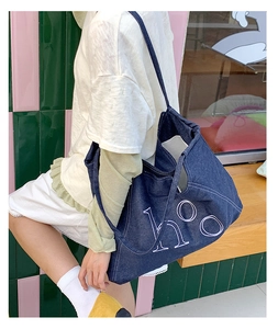 Detail shot of the large denim tote bag featuring the stylish hOO lettering and wide strap