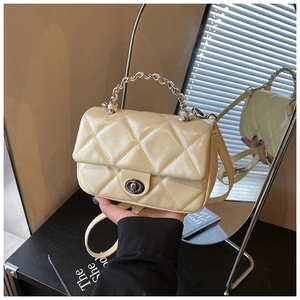 Detail of quilted small square bag with silver metal handle and classic twist lock