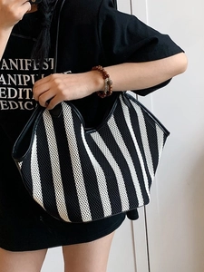 Modern black and white striped mesh tote bag with a minimalist woven design for women