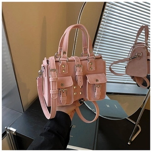 Detail of pink matte mini Boston bag featuring silver studs and small buckle pockets