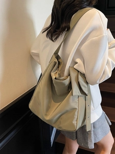 Olive green slouchy hobo bag with eyelet strap shown as a crossbody commuter tote
