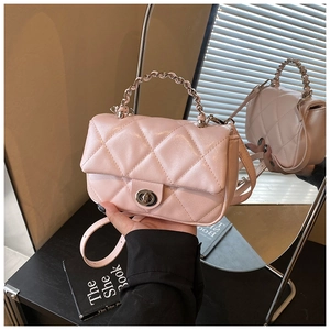 Detail of pink quilted handbag featuring metallic chain handle and silver twist lock closure