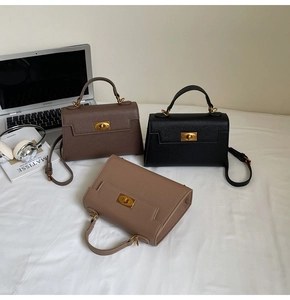 Detailed view of fashionable leather Kelly bags in brown, black, and khaki with gold hardware