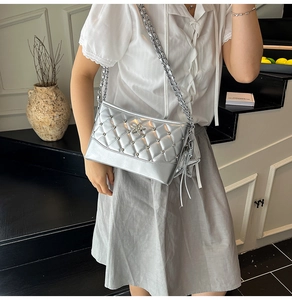 Close-up of silver quilted crossbody bag with metallic studs and star decoration