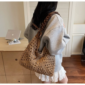Detail of the woven geometric pattern and brown leather scrunchie strap on the tote bag