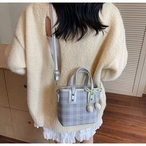 Detail of silver checkered bucket bag with tulip charms and green bow decoration