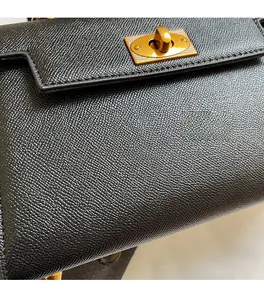 Close-up of soft black pebble leather texture and gold metal twist lock on the bag