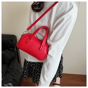 Détail de la texture cuir litchi rouge vif sur le sac à main Boston élégant