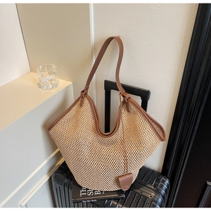 Détail du grand sac cabas en paille tissée avec poignées en cuir marron de qualité