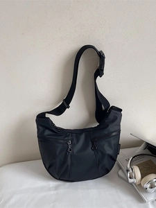 Fashionable black nylon crescent crossbody bag with double front zippers and wide strap