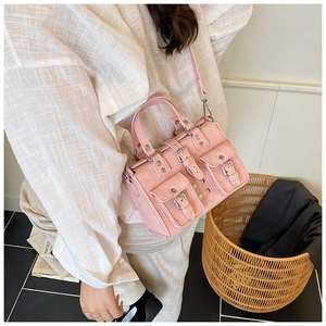 Detailed close-up of a pink Y2K style multi-pocket handbag with silver metal buckles