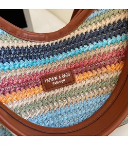 Détail d'un sac en paille tressée colorée avec logo en cuir et texture à rayures