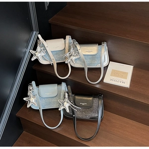 Chic underarm bags in denim and tweed finishes with star charms on dark wooden steps