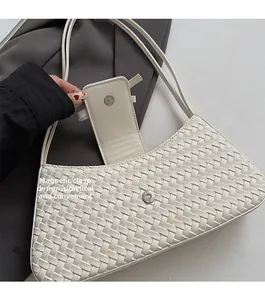 Détail du sac baguette blanc tressé avec doubles bretelles et fermeture magnétique