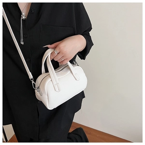 Gros plan sur le cuir grainé blanc d'un sac Boston avec détails de fermeture éclair argentée