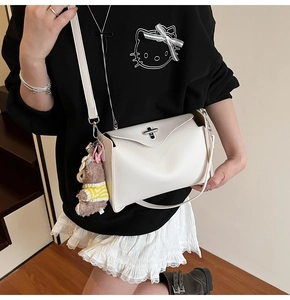 Detail of white lychee pattern Boston bag with silver twist lock and cute bear charm