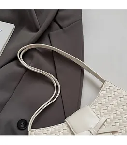 Détail du sac en cuir tressé blanc crème avec nœud et fines bandoulières élégantes
